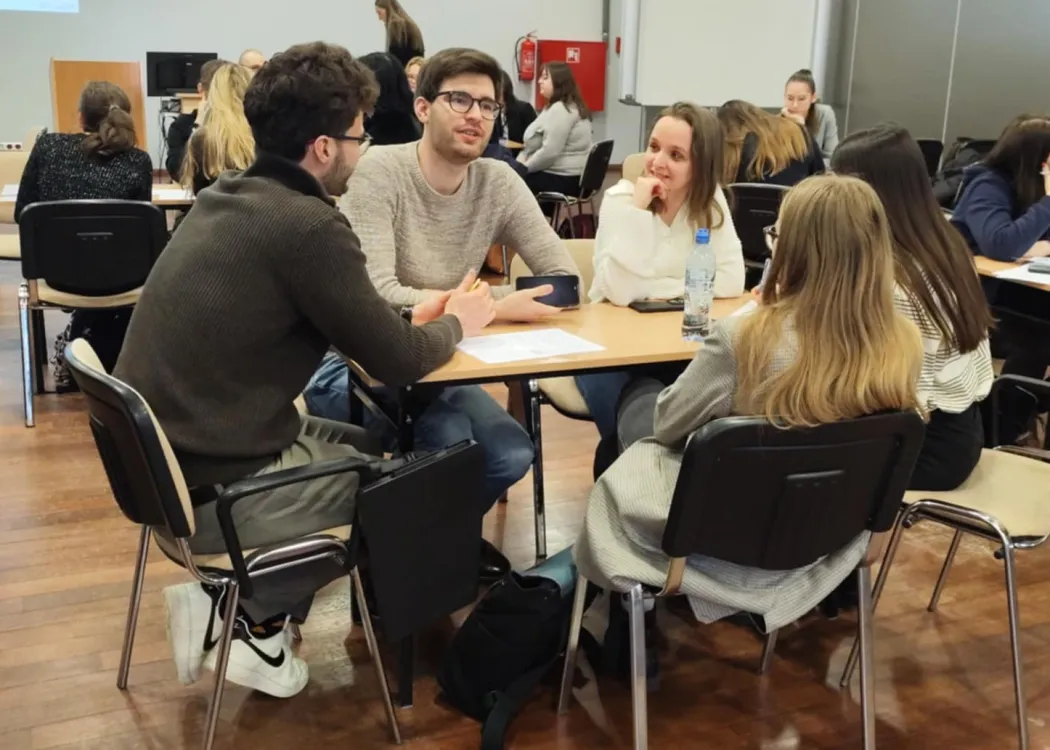 studenci siedzą i omawiają plan biznesowy przedsiębiorstwa społecznego