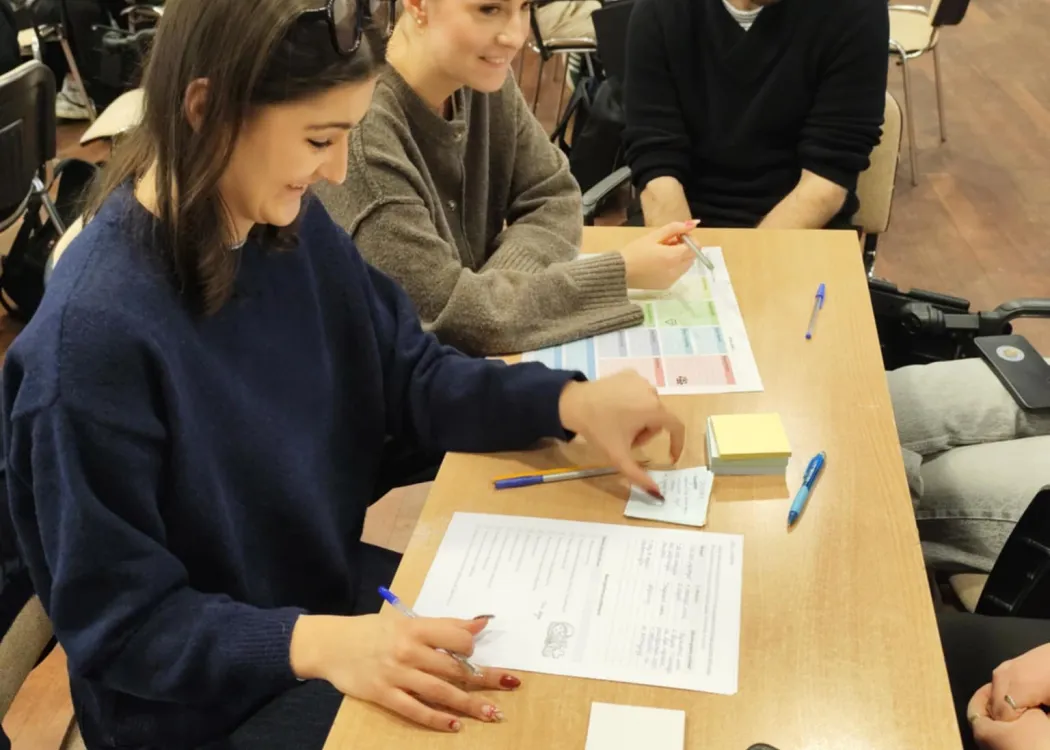 studenci siedzą i omawiają plan biznesowy przedsiębiorstwa społecznego