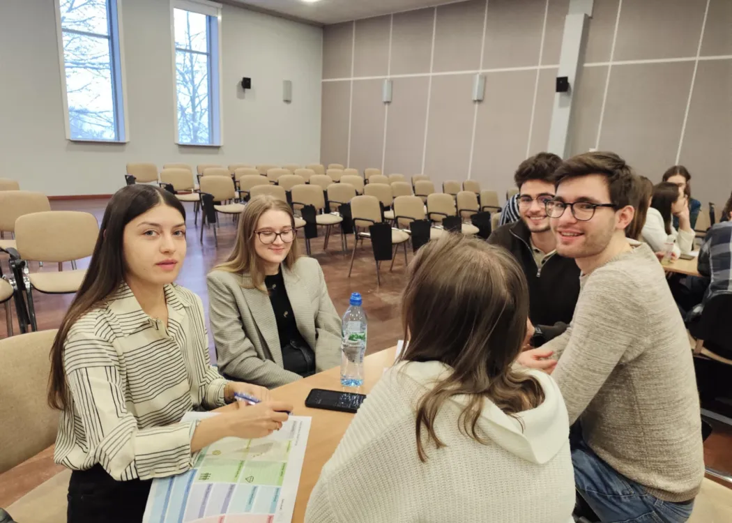 studenci siedzą i omawiają plan biznesowy przedsiębiorstwa społecznego