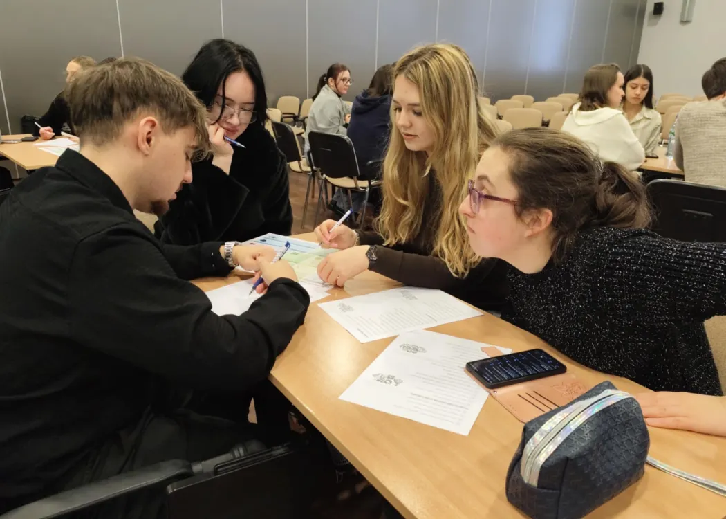studenci siedzą i omawiają plan biznesowy przedsiębiorstwa społecznego
