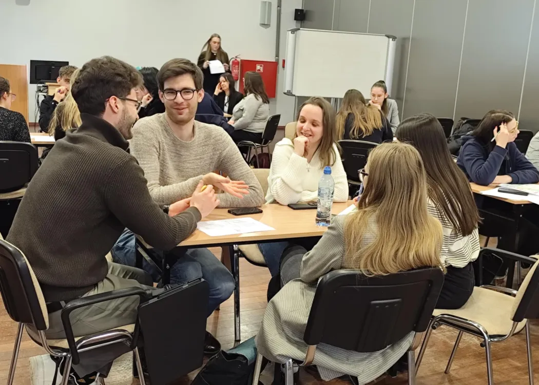 studenci siedzą i omawiają plan biznesowy przedsiębiorstwa społecznego