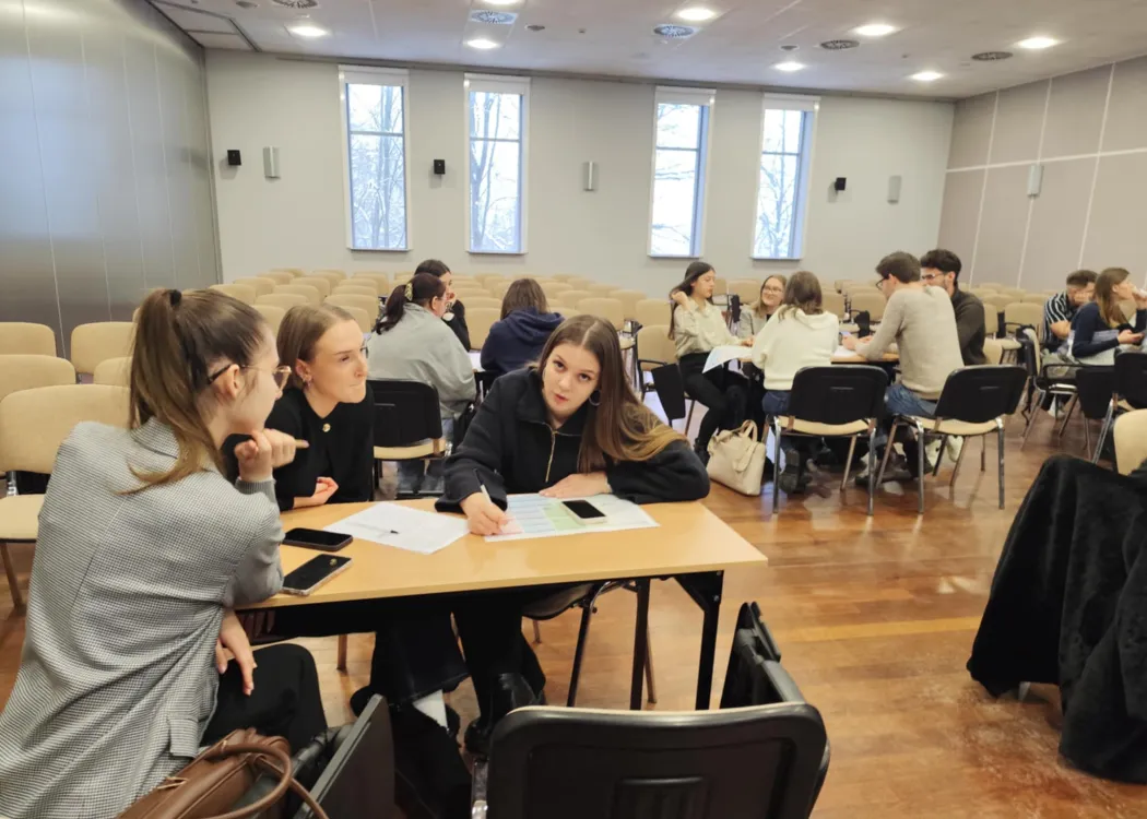 studenci siedzą i omawiają plan biznesowy przedsiębiorstwa społecznego