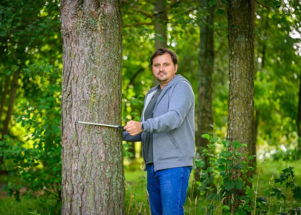 Sławomir Piętka stoi przy drzewie