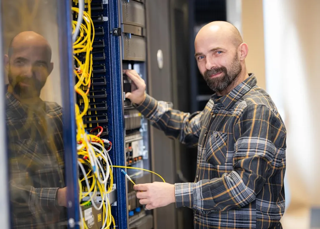 Dr Jan Jastrzębski stoi obok maszyny informatycznej, fot. Janusz Pająk 