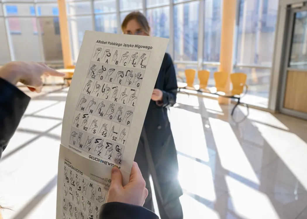 na zdjęciu widać kartkę papieru z alfabetem języka migowego, zostało ono zrobione podczas obchodów Europejskiego Dnia Logopedy w 2025 roku 