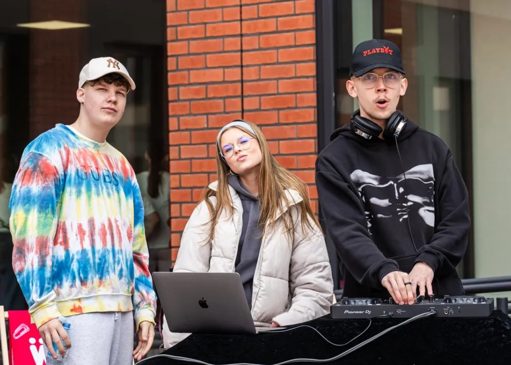 Dzień Otwarty UWM 2026: studenci podczas pełnienia funkcji DJ-ów przed jednym z budynków 