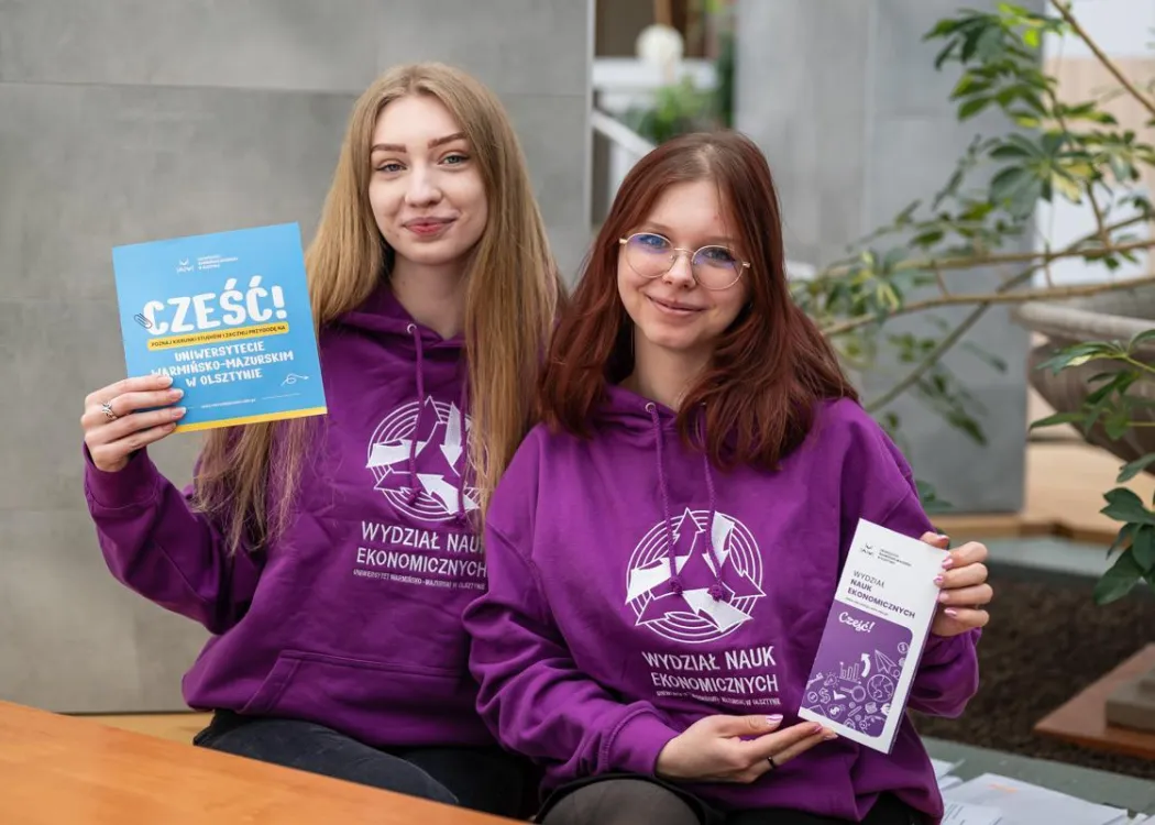 Dzień Otwarty UWM 2026: studentki Wydziału Nauk Ekonomicznych pozują do zdjęcia z ulotką wydziału