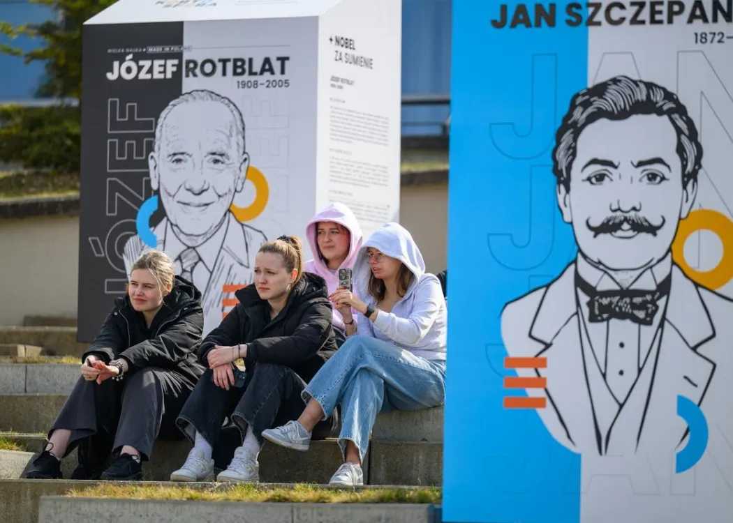 Dzień Otwarty UWM 2026: młodzi ludzie siedzą w miejscu, gdzie znajduje się wystawa Kortosfery "Wielka Nauka Made in Poland"