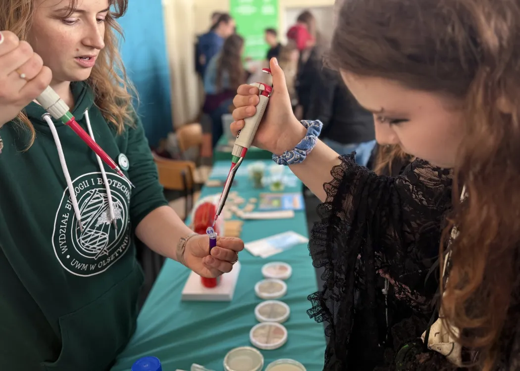 Giełda pomysłów na życie 2026: uczestniczka wydarzenia robi doświadczenia na stoisku Wydziału Biologii i Biotechnologii 