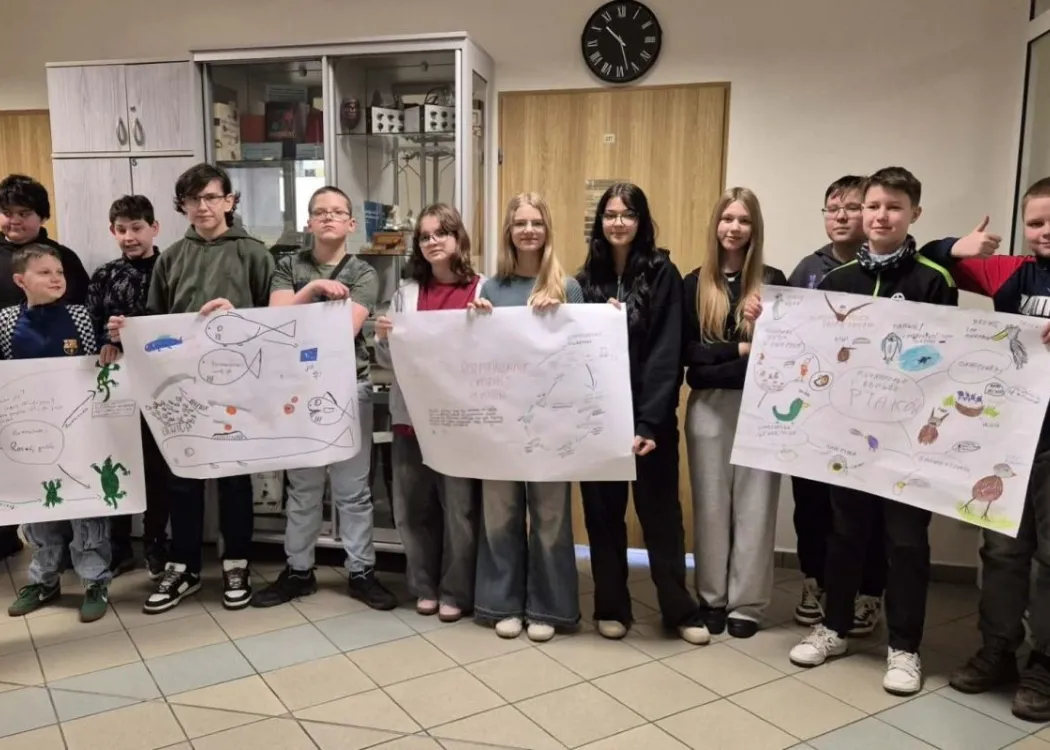 młodzież stoi z kartkami