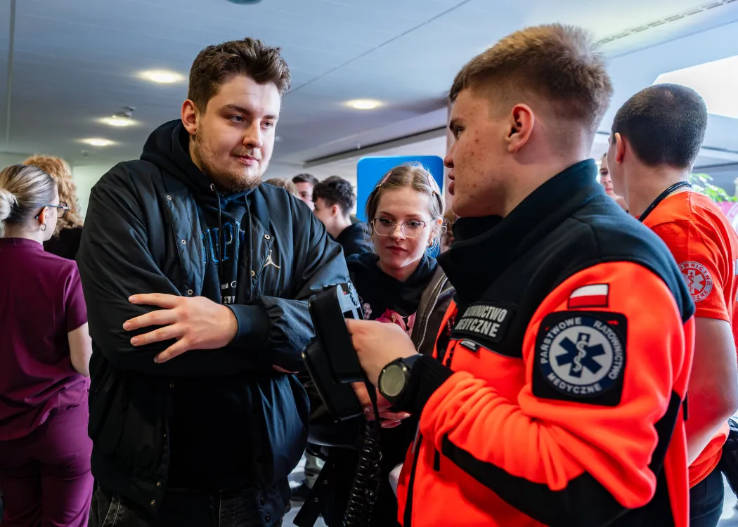 Dzień Otwarty UWM 2026: Przedstawiciel kierunku ratownictwo medyczne rozmawia z uczestnikiem