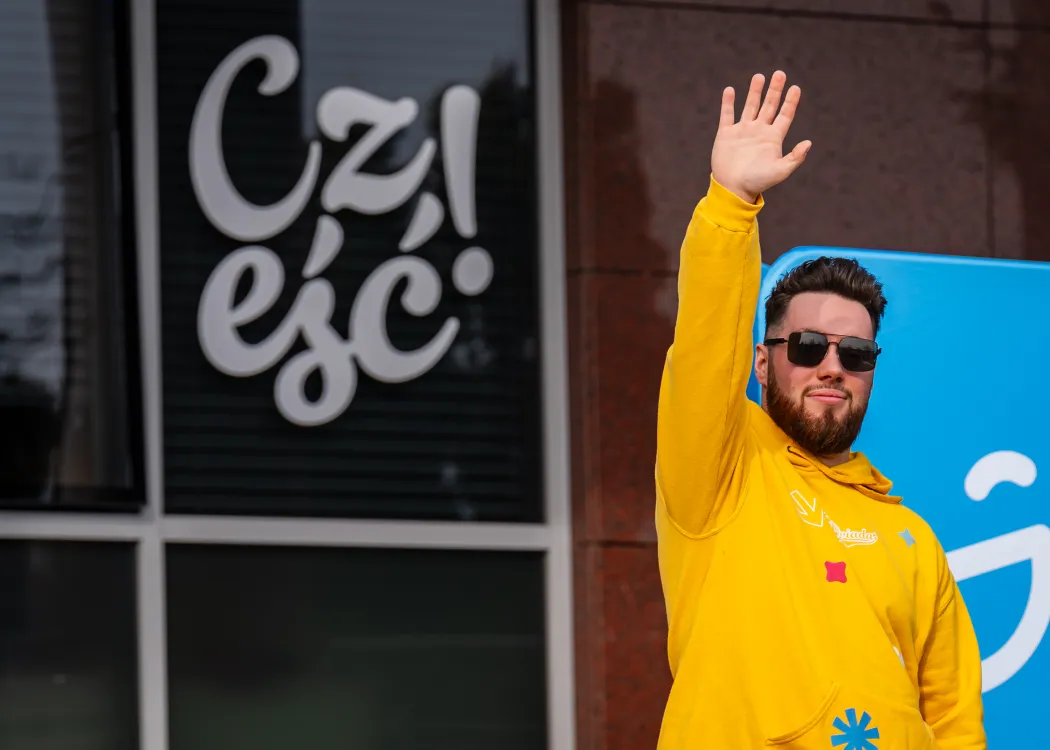 Dzień Otwarty UWM 2026: członek samorządu studenckiego macha przed Biblioteką Uniwersytecką 