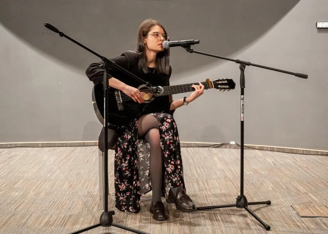 studentka występująca na scenie z gitarą