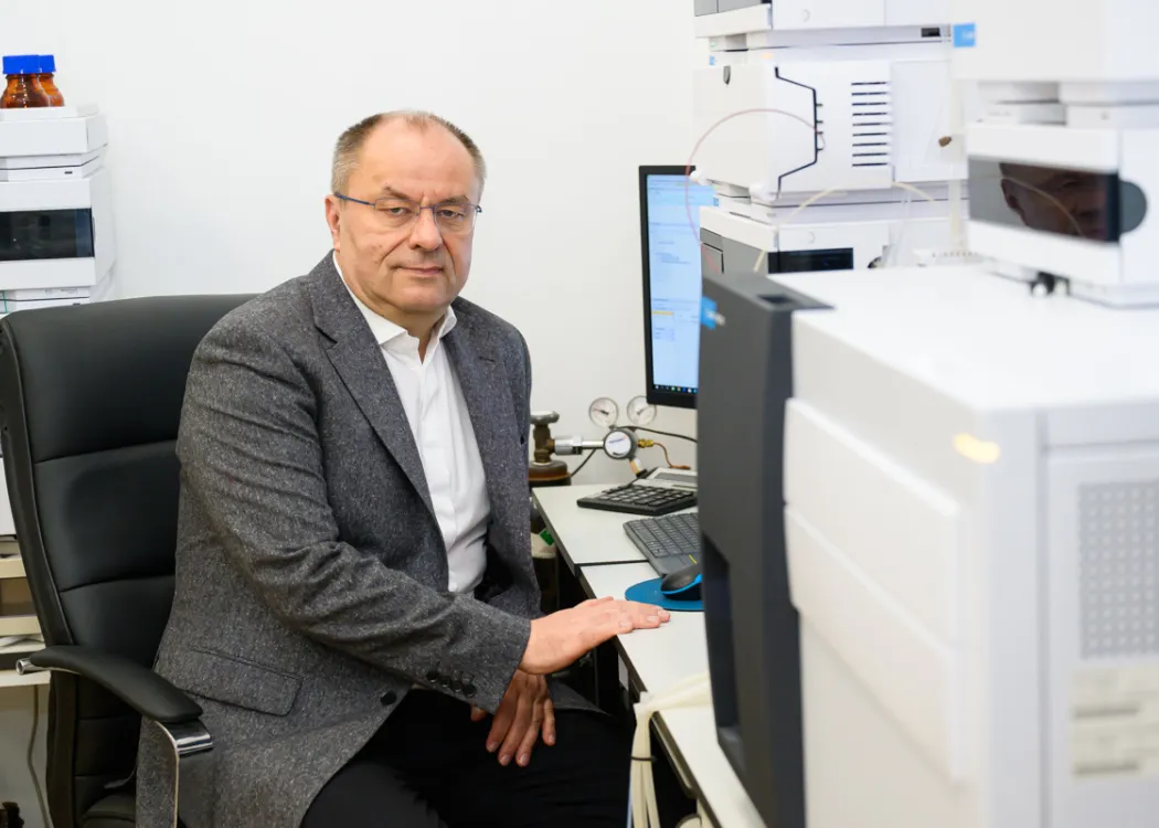 Prof. Łukasz Zielonka siedzi przy biurku