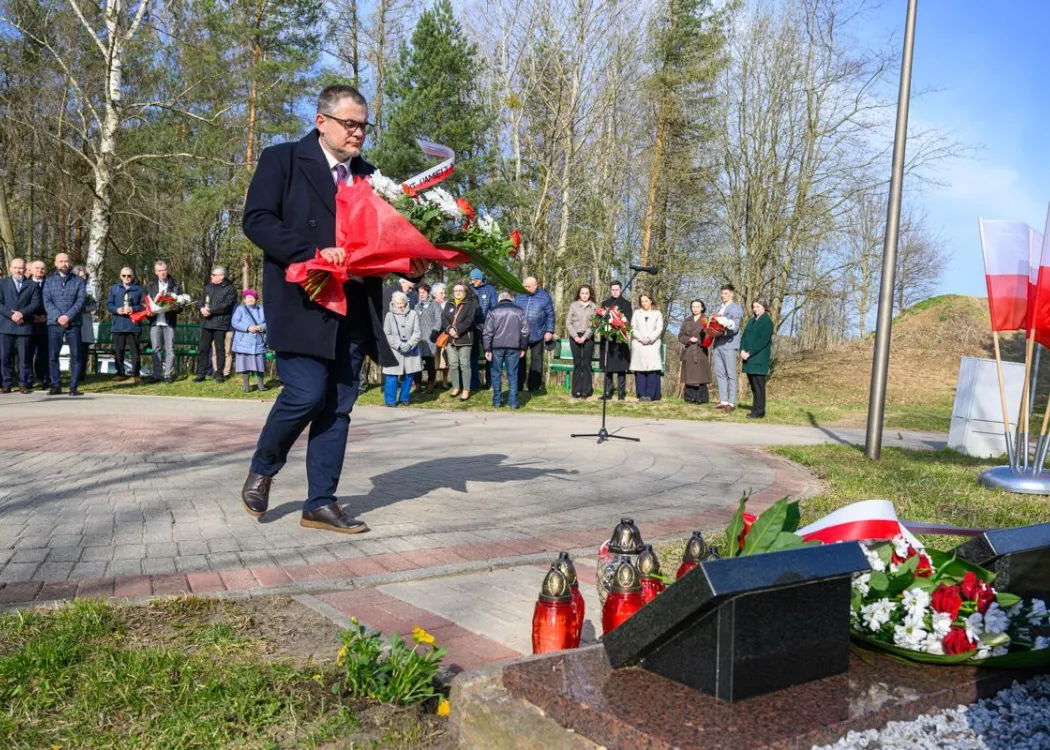Dr hab. Karol Sacewicz, prof. UWM składa kwiaty pod tablicą pamiątkową podczas uroczystości upamiętniającej ofiary zbrodni katyńskiej. 