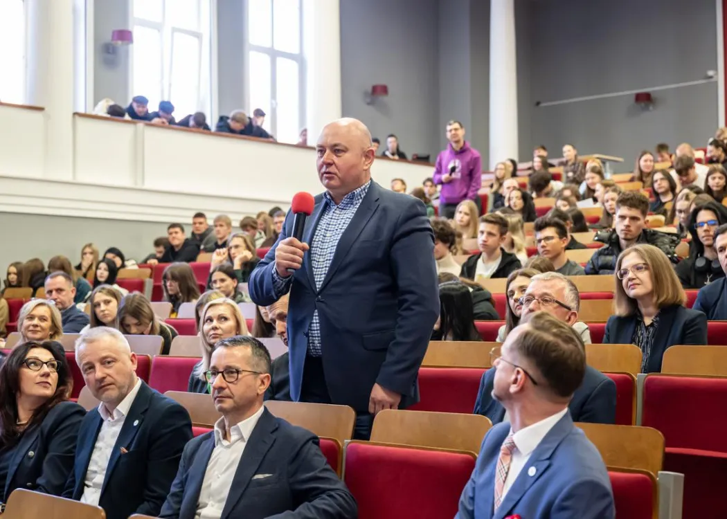 Uczestnicy dnia z ekonomią siedzą, naukowiec zadaje pytanie