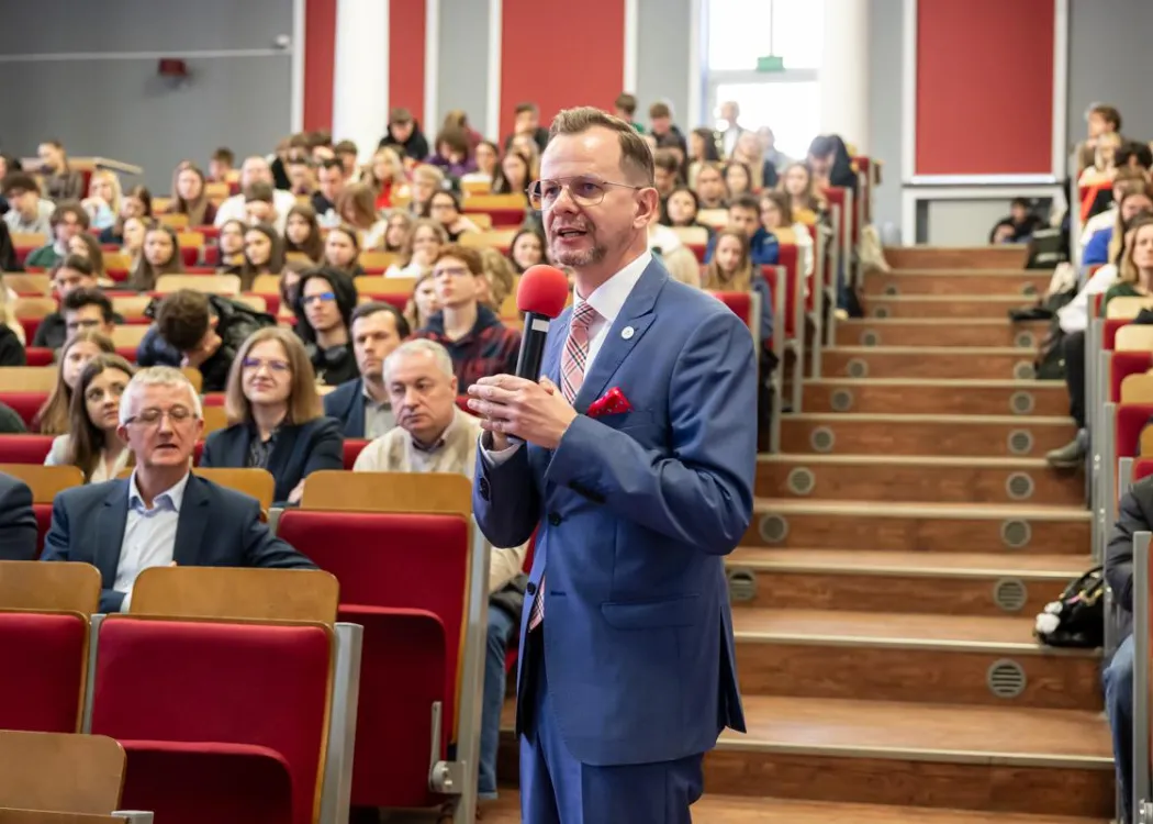 Uczestnicy dnia z ekonomią siedzą, prowadzący zadaje pytanie