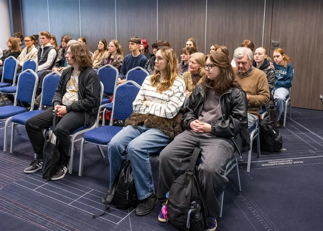 Młodzież siedzi i uczestnicy w spotkania