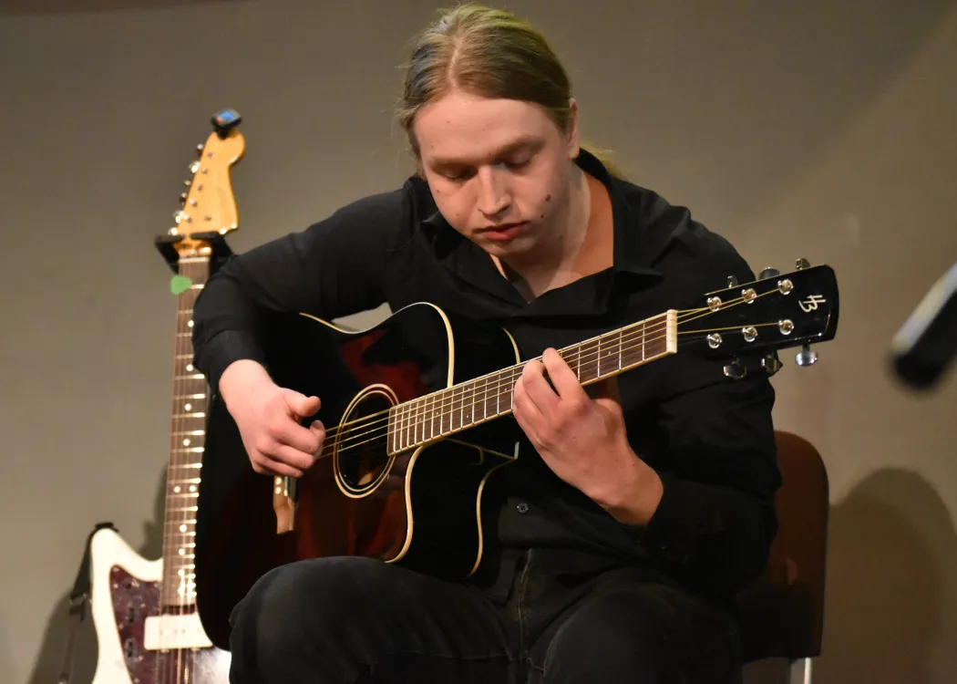 Student z gitarą na scenie podczas koncertu 