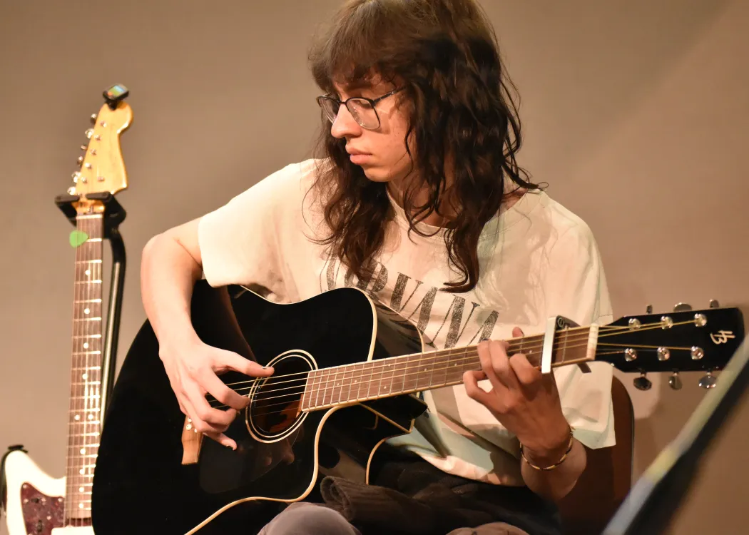 Student z gitarą na scenie podczas koncertu 