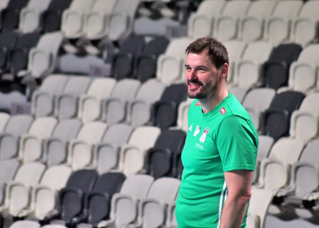 Daniel Pliński stoi na tle trybun 