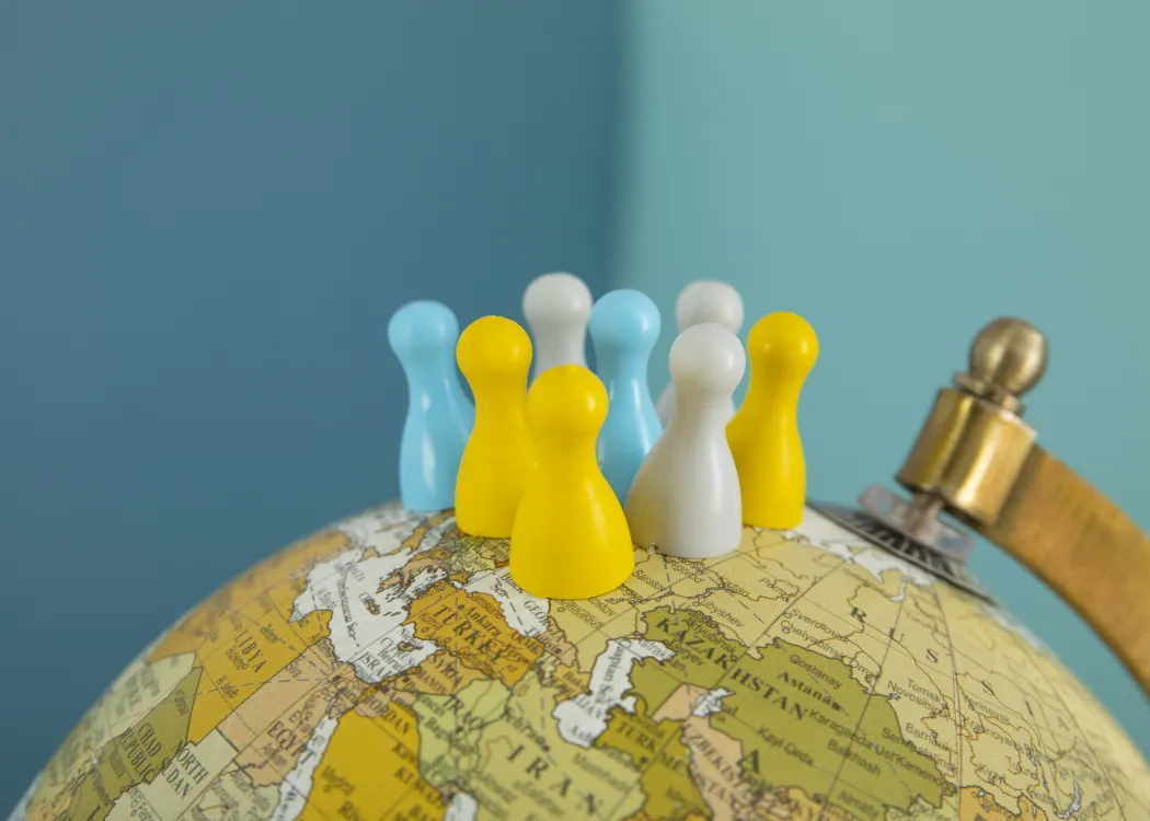 grafika, na której widać pionki i globus, ilustrująca politykę międzynarodową przywódców państw