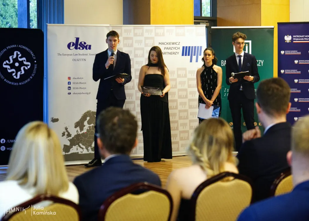 Cztery osoby stoją przed publicznością podczas gali 25-lecia ELSA Olsztyn
