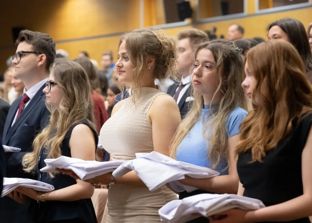 Biały Fartuch 2026 na UWM: studenci trzymają fartuchy w swoich dłoniach