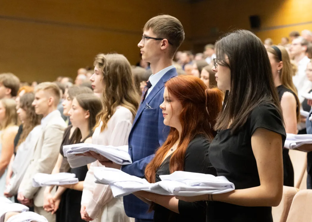 Biały Fartuch 2026 na UWM: studenci trzymają fartuchy w swoich dłoniach