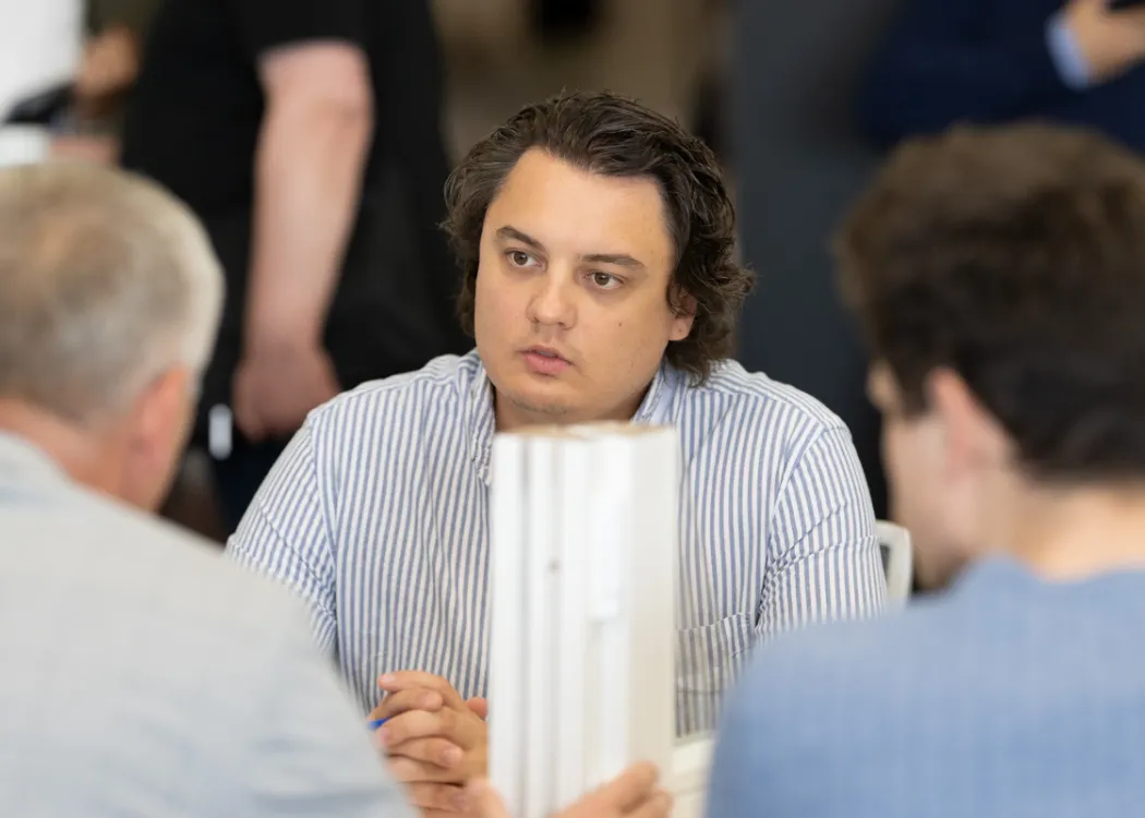 przedsiębiorcy podczas rozmów B2B, siedzą przy stole i przedstawiają ofertę swoich firm