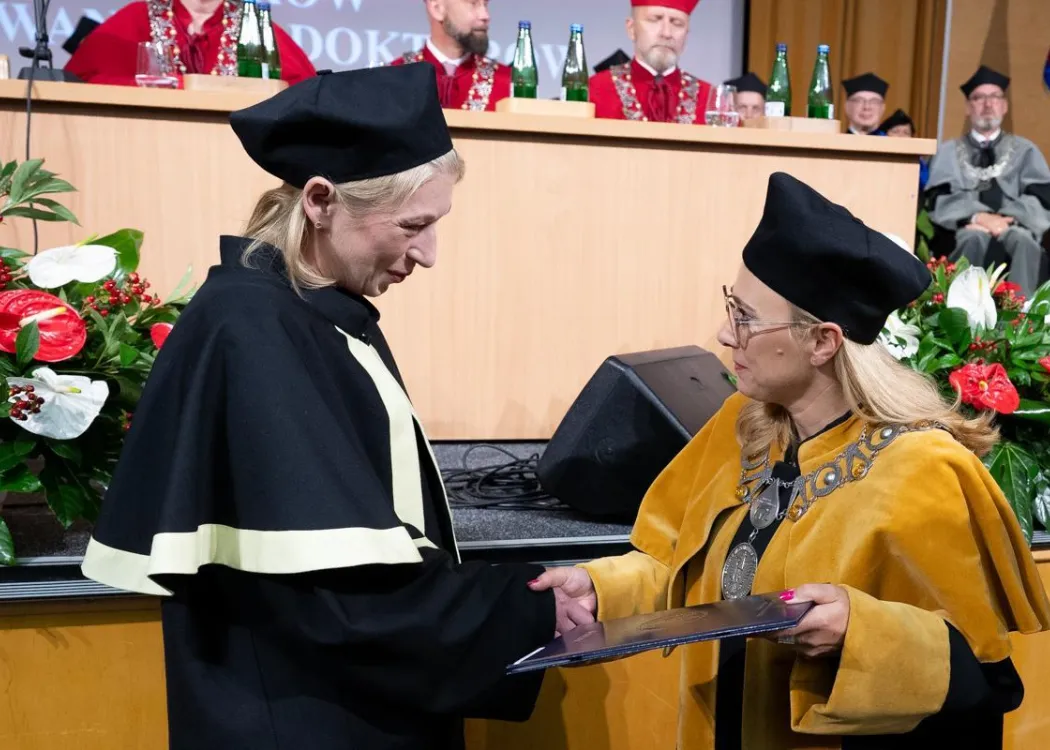 Święto Uniwersytetu 2026: pracownica UWM odbiera dyplom od dziekan 