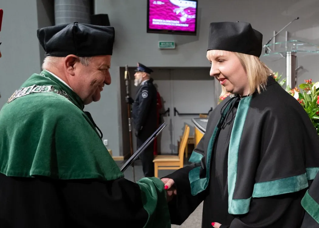 Święto Uniwersytetu 2026: pracownica UWM odbiera dyplom z rąk dziekana