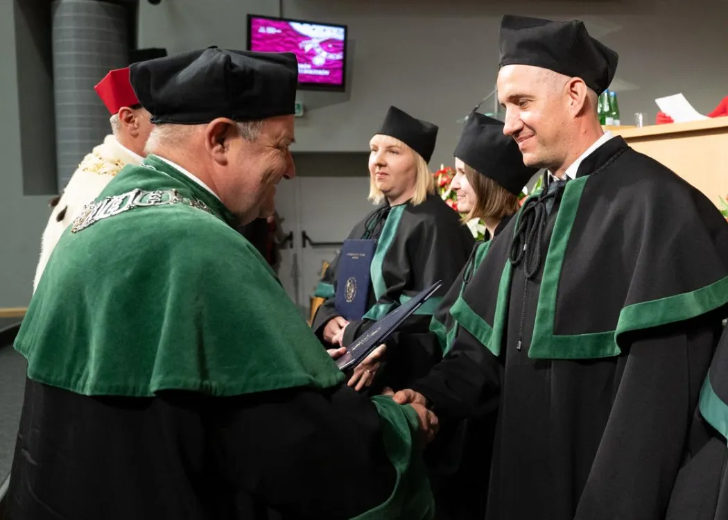 Święto Uniwersytetu 2026: pracownik UWM odbiera dyplom z rąk dziekana