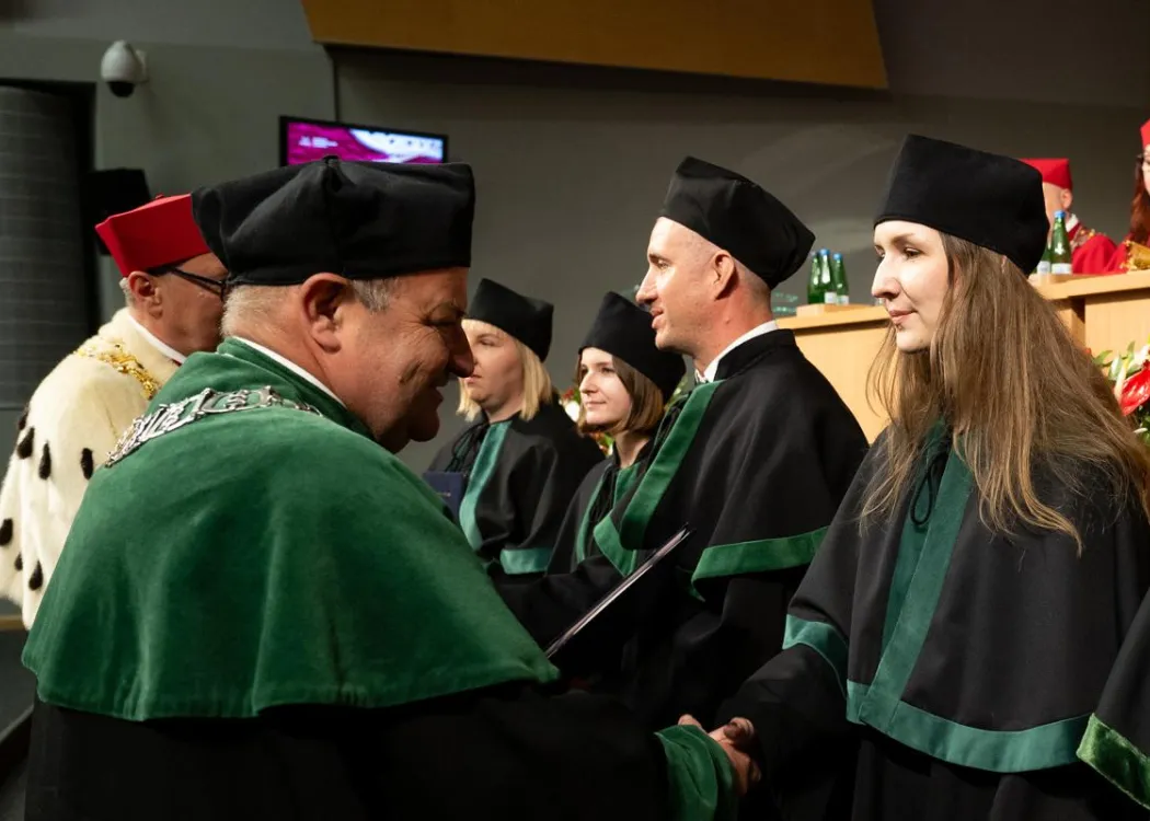 Święto Uniwersytetu 2026: pracownica UWM odbiera dyplom z rąk dziekana
