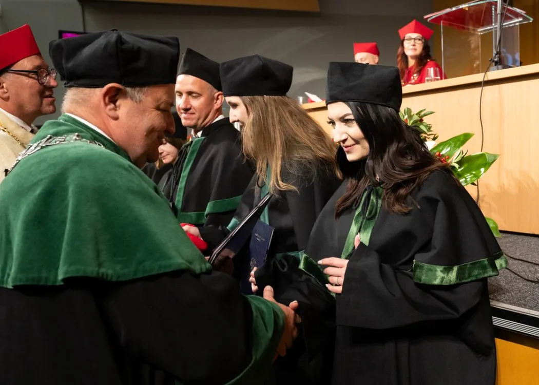 Święto Uniwersytetu 2026: pracownica UWM odbiera dyplom z rąk dziekana