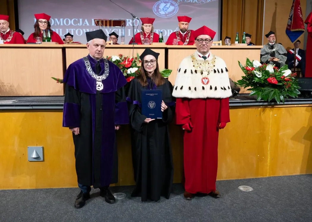 Święto Uniwersytetu 2026: pracownica UWM, która odebrała dyplom, pozuje do zdjęcia