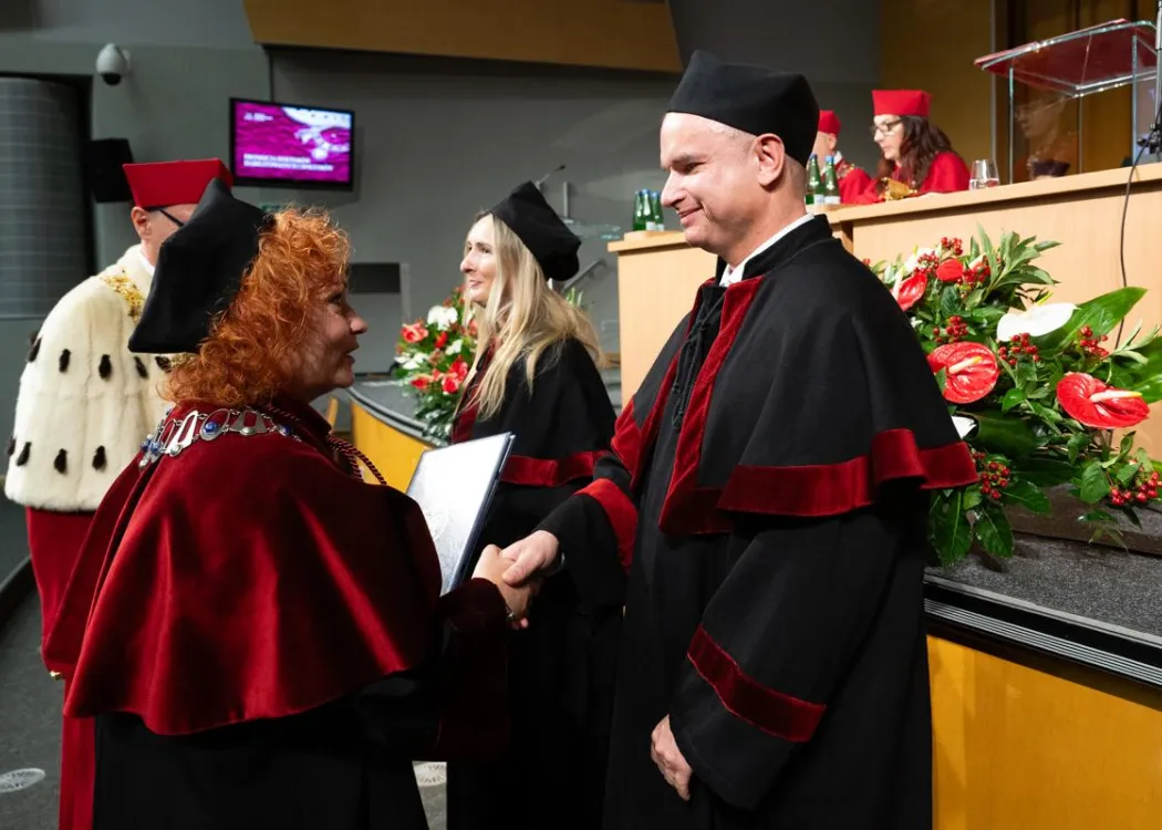 Święto Uniwersytetu 2026: pracownik UWM odbiera dyplom z rąk dziekana