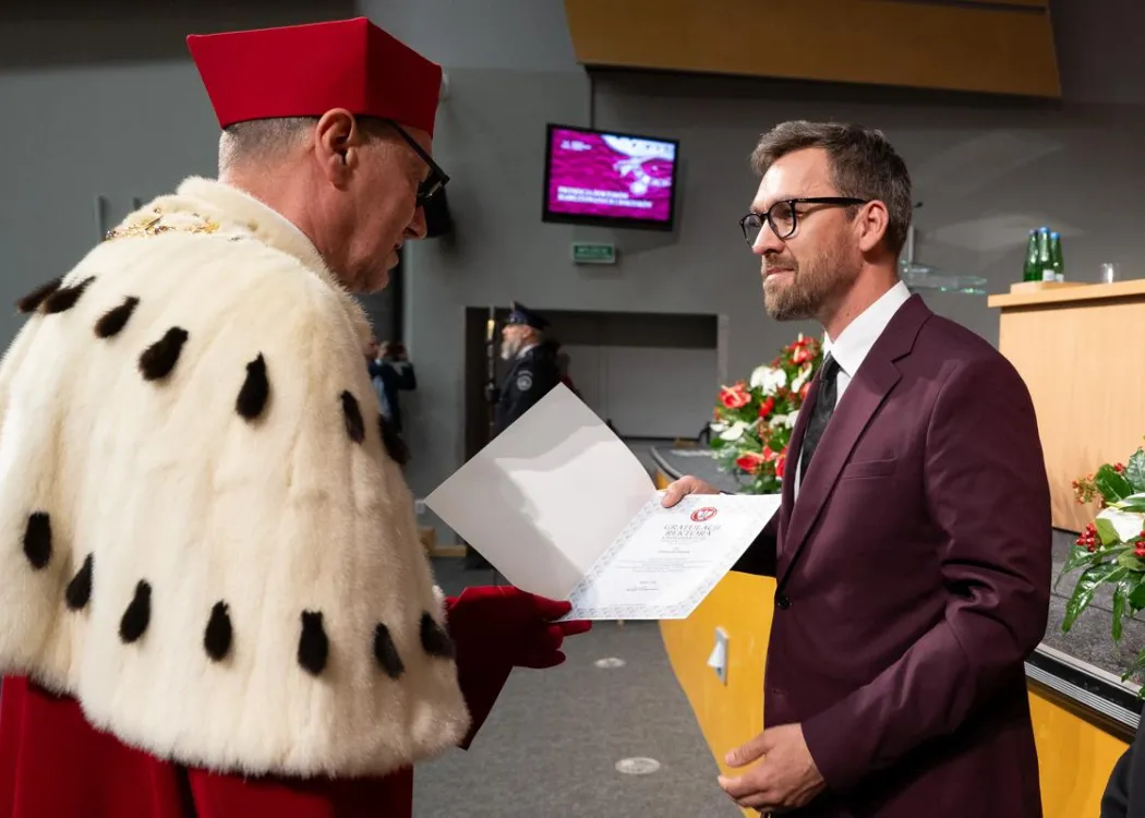 Święto Uniwersytetu 2026: osoba wyróżniona odbiera dyplom