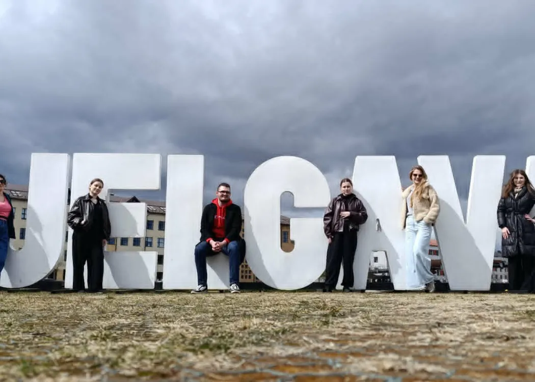 Uczestnicy BIP stoją przy dużym napisie Jelgawa 