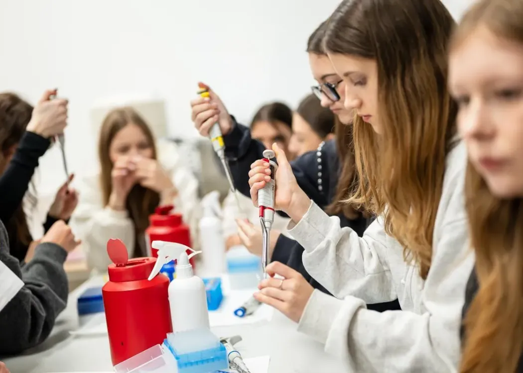 Młodzież w laboratorium z pipetami