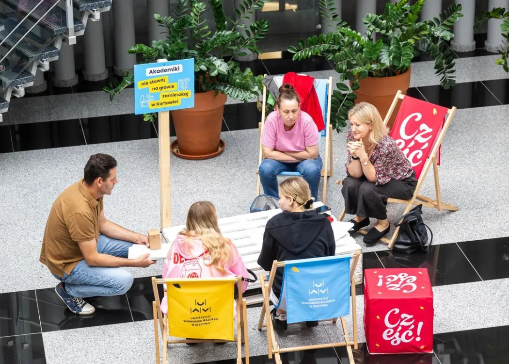 Strefa Kandydata UWM 2026: kandydaci na studia siedzą i rozmawiają przy jednym ze stoisk