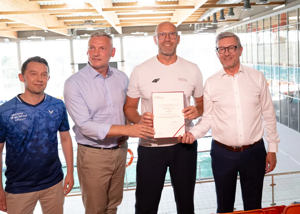 od prawej: prof. Jerzy Przyborowski - rektor UWM, Jakub Rutnicki - minister sportu i turystyki, Paweł Papke, poseł oraz przedstawiciel Samorządu Województwa Warmińsko-Mazurskiego pozują na tle pływalni uniwersyteckiej