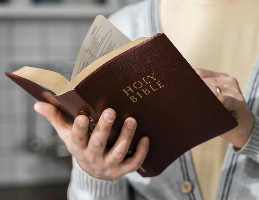 Osoba trzyma Biblię w dłoni, fot. pixabay.com