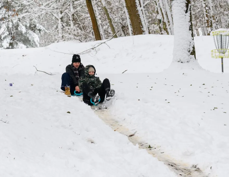 dwie osoby zjeżdżające na jabłku w Kortowie 