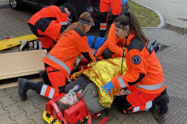 ratownicy udzielają pierwszej pomocy poszkodowanemu na ulicy