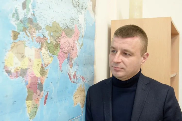 prof. Żęgota na tle mapy świata