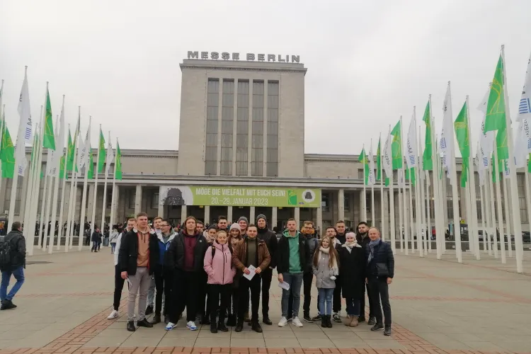 studenci stoją przed wejściem na targi