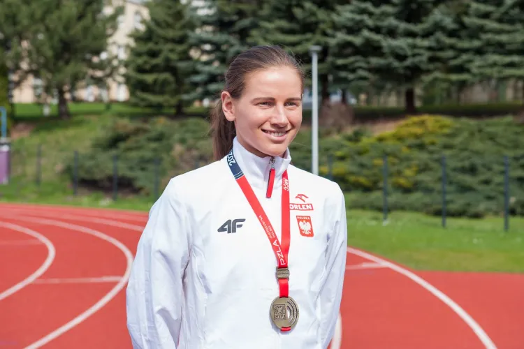 Aleksanda Lisowska z  AZS UWM stoi z medalem na stadionie