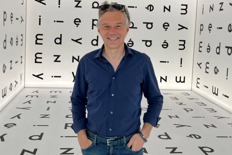 Prof. Mariusz Rutkowski na tle liter