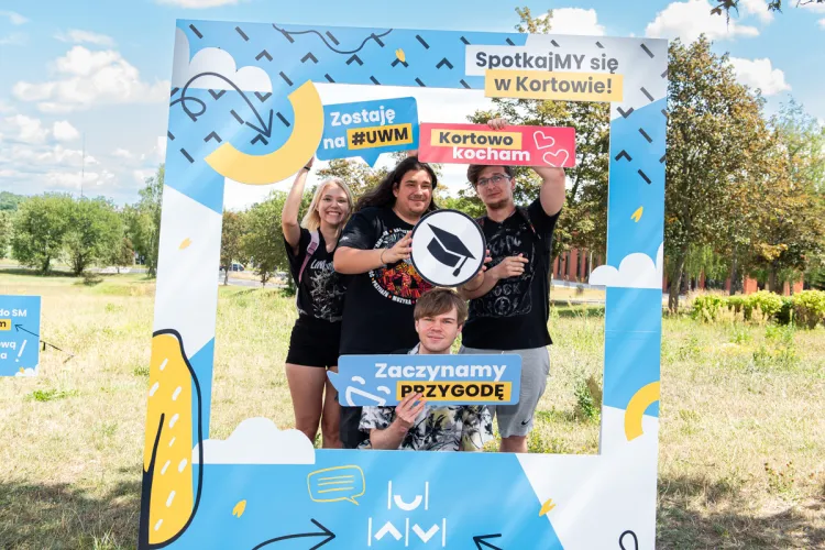 Nowi studenci UWM pozują do zdjęcia w ramce